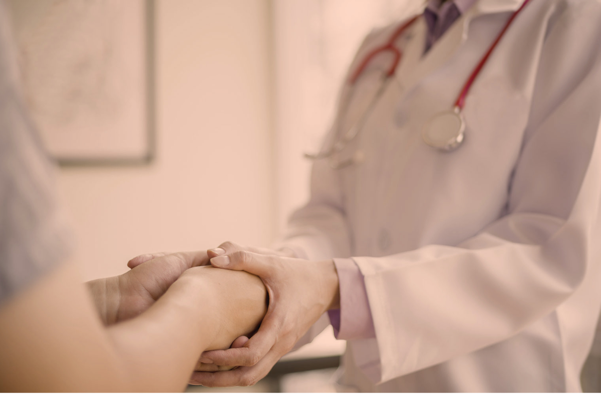 Doctor holding patient's hands representing health insurance