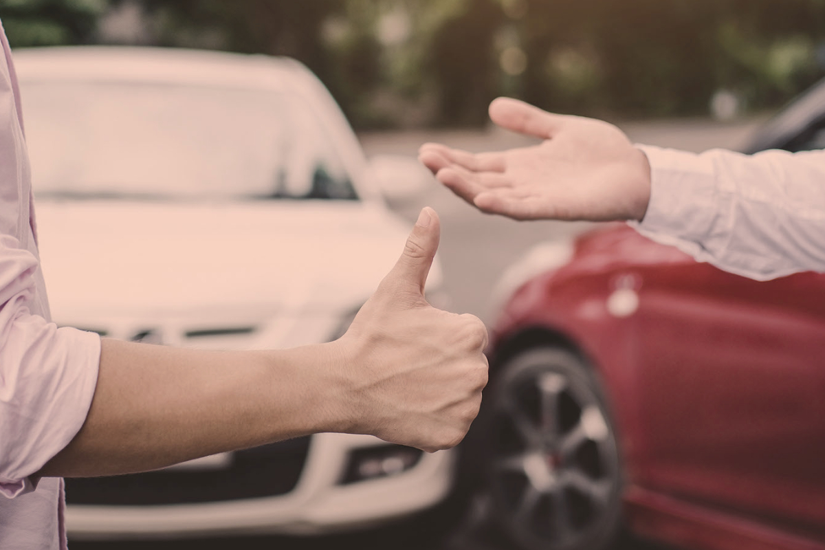 Two people in front of cars representing auto insurance